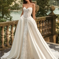 Bride wearing the Enzoani WANDA wedding dress, a romantic strapless lace fit-and-flare bridal gown with an illusion corset bodice and detachable satin overskirt, perfect for luxury, modern, and destination weddings.