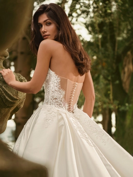 Bride wearing the Enzoani WANDA wedding dress, a romantic strapless lace fit-and-flare bridal gown with an illusion corset bodice and detachable satin overskirt, perfect for luxury, modern, and destination weddings.