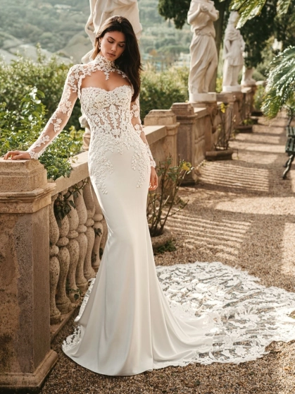 Enzoani Waverly wedding dress featuring a fitted mermaid silhouette, illusion lace bodice, high neckline, long lace sleeves, and dramatic lace train. Luxury designer bridal gown by Enzoani for modern brides seeking elegant, romantic, couture wedding dresse