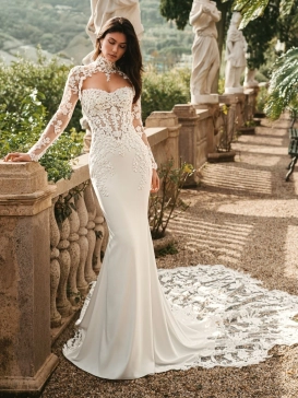 Enzoani Waverly wedding dress featuring a fitted mermaid silhouette, illusion lace bodice, high neckline, long lace sleeves, and dramatic lace train. Luxury designer bridal gown by Enzoani for modern brides seeking elegant, romantic, couture wedding dresse