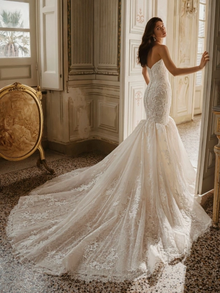 Enzoani Willa wedding dress. A luxury strapless mermaid bridal gown featuring a structured sweetheart neckline bodice adorned with intricate floral lace appliqués and subtle beadwork. The fitted silhouette hugs the hips before flaring into a dramatic lace