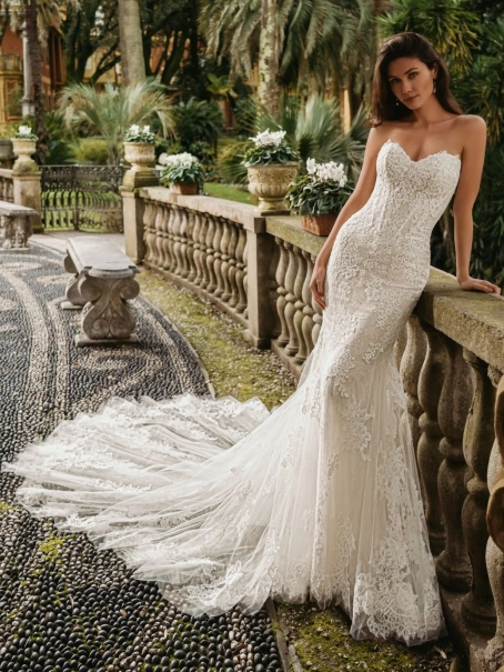 Enzoani luxury wedding dress featuring a romantic mermaid silhouette with intricate floral lace appliqué, fitted sweetheart bodice, illusion detailing and a dramatic cathedral-length tulle train. Designed for modern brides seeking a designer wedding dress