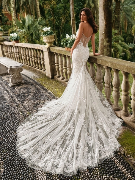 Enzoani luxury wedding dress featuring a romantic mermaid silhouette with intricate floral lace appliqué, fitted sweetheart bodice, illusion detailing and a dramatic cathedral-length tulle train. Designed for modern brides seeking a designer wedding dress