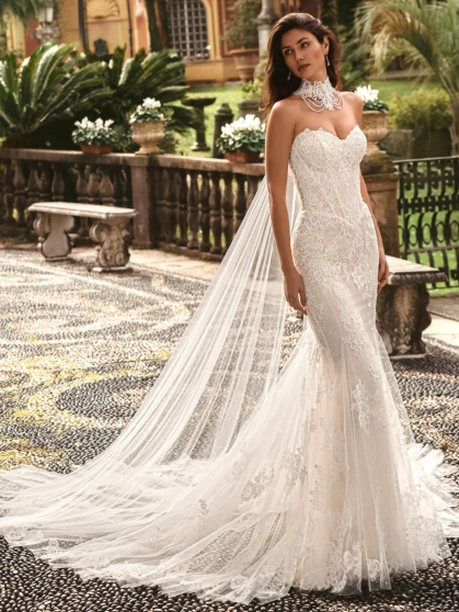 Enzoani luxury wedding dress featuring a romantic mermaid silhouette with intricate floral lace appliqué, fitted sweetheart bodice, illusion detailing and a dramatic cathedral-length tulle train. Designed for modern brides seeking a designer wedding dress
