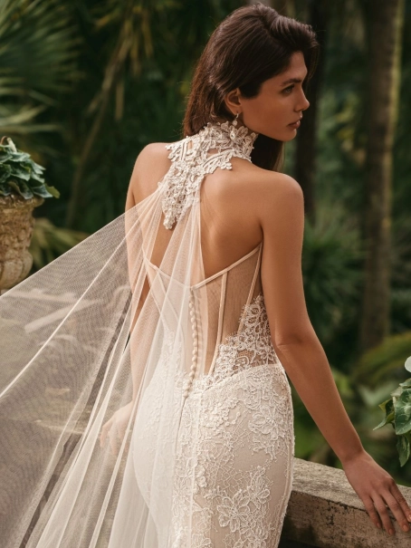 Enzoani luxury wedding dress featuring a romantic mermaid silhouette with intricate floral lace appliqué, fitted sweetheart bodice, illusion detailing and a dramatic cathedral-length tulle train. Designed for modern brides seeking a designer wedding dress