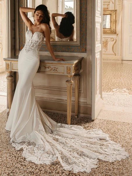 Enzoani Wilomina luxury wedding dress featuring a structured corset bodice, satin A-line silhouette, detachable overskirt and dramatic cathedral train.