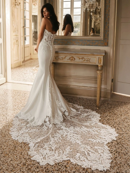 Enzoani Wilomina luxury wedding dress featuring a structured corset bodice, satin A-line silhouette, detachable overskirt and dramatic cathedral train.
