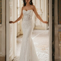 Enzoani Winnie is a luxury mermaid wedding dress featuring intricate floral lace embroidery, dimensional appliqué detailing, illusion corsetry and a sculpted sweetheart neckline. Designed for brides seeking a fitted designer wedding gown that combines cout