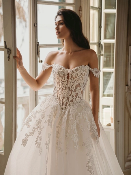 Enzoani Winona luxury ballgown wedding dress featuring an illusion corset bodice, off-the-shoulder straps, floral lace appliqué and cathedral train.