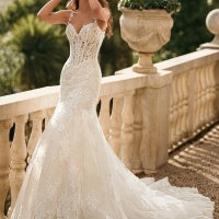 Enzoani Winslet is a luxury mermaid wedding dress featuring intricate floral lace appliqué, illusion corsetry, delicate lace shoulder straps and a softly flared lace train. Designed for brides seeking a fitted designer wedding gown that combines couture cr