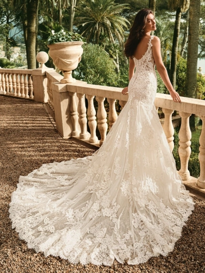 Enzoani Winslet is a luxury mermaid wedding dress featuring intricate floral lace appliqué, illusion corsetry, delicate lace shoulder straps and a softly flared lace train. Designed for brides seeking a fitted designer wedding gown that combines couture cr