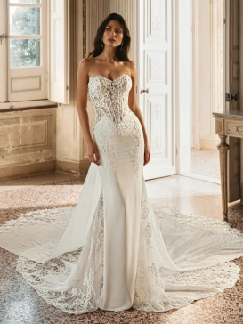 Enzoani Winter is a luxury fitted wedding dress featuring an intricately embroidered illusion corset bodice, sculpted sweetheart neckline, elegant crepe skirt and dramatic detachable lace train. Designed for brides seeking a sophisticated designer wedding