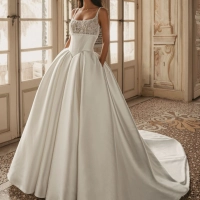 Enzoani Wren is a luxury satin ballgown wedding dress featuring a delicately embroidered lace bodice, elegant square neckline, supportive shoulder straps and a dramatic cathedral-length train. Designed for brides seeking a timeless designer wedding gown th