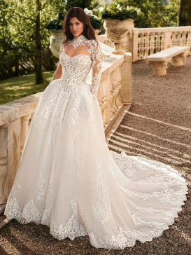 Enzoani Wynn is a luxury princess ballgown wedding dress featuring a high illusion neckline, long lace sleeves, structured corset bodice and intricate embroidered lace detailing throughout. Designed for brides seeking a regal designer wedding gown with cou