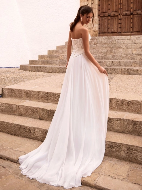 Love by Enzoani FENORA-A is a versatile two-piece designer wedding dress featuring an intricately embellished lace corset bodice paired with a lightweight chiffon A-line skirt. Combining modern bridal fashion with timeless romance, this luxury wedding gown