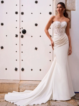 Love by Enzoani FOSIRA is a glamorous fit and flare wedding dress that combines a sparkling beaded illusion corset bodice with luxurious crepe. Featuring a romantic sweetheart neckline, exposed corset boning, intricate beadwork and soft draping across the
