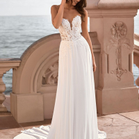 Love by Enzoani FRANCETTE is a romantic chiffon A-line wedding dress featuring an illusion lace corset bodice adorned with delicate floral lace appliqués, a plunging sweetheart neckline and a soft flowing chiffon skirt. Combining lightweight movement with